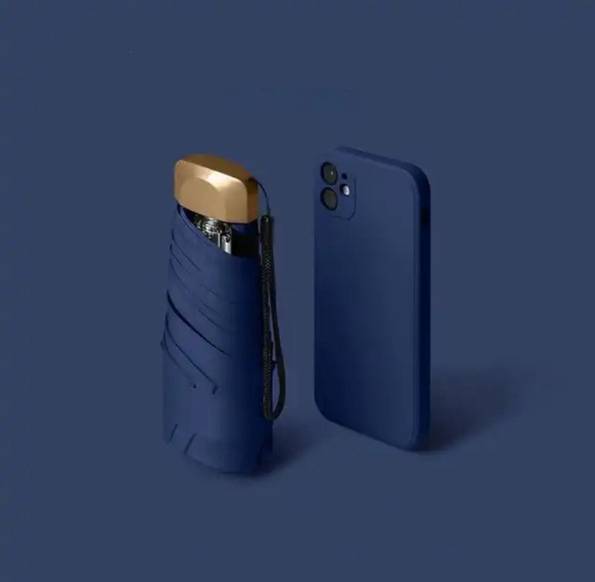 Dark blue mini travel umbrella, folded pocket size with carry strap and gold cap.