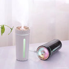 Pink column aroma diffuser humidifier with black car adapter, emitting mist