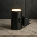 Black cylindrical plug-in LED night light with warm-lit top and two-prong plug