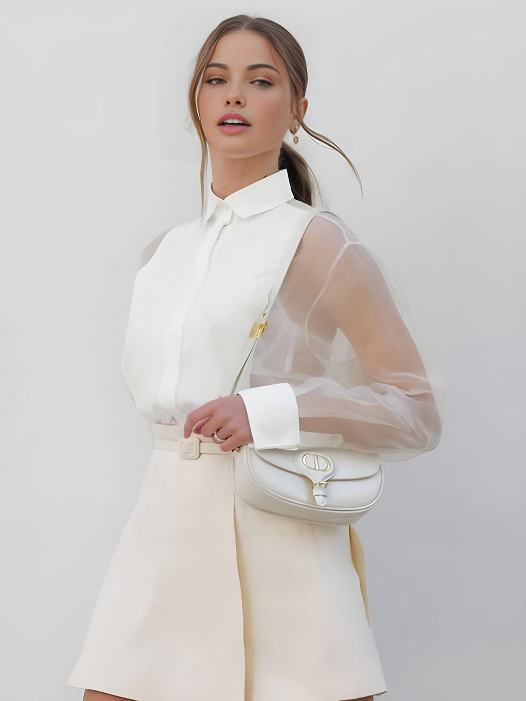 White collared button-up blouse with sheer mesh sleeves and hidden front placket