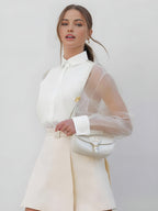 White collared button-up blouse with sheer mesh sleeves and hidden front placket