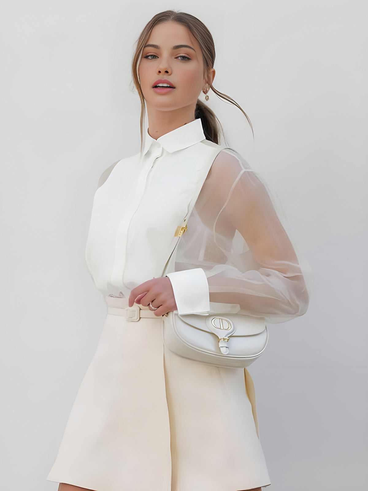 White collared button-up blouse with sheer mesh sleeves and hidden front placket