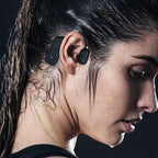 Black open-ear bone conduction wireless headphones worn by woman