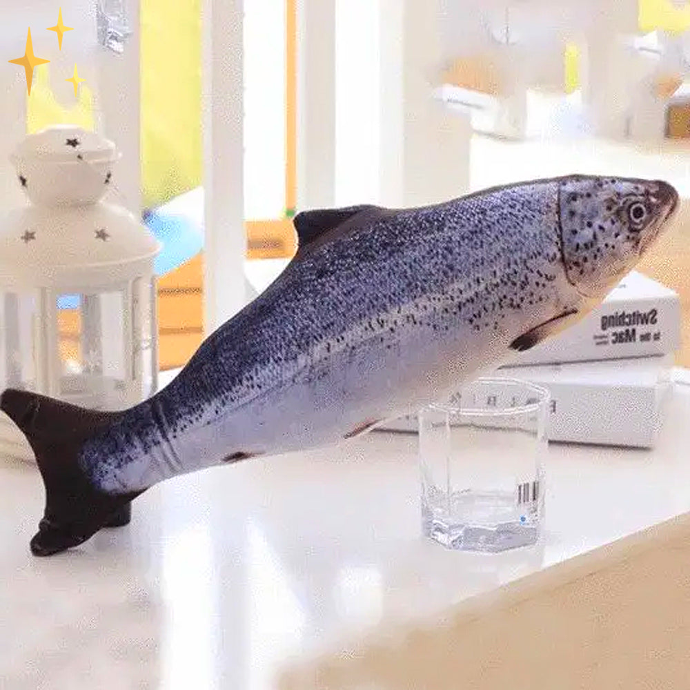 Plush gray-blue cat fish toy with speckled pattern, lying on white surface