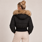 Black cropped puffer jacket back view with faux fur hood trim and ribbed hem