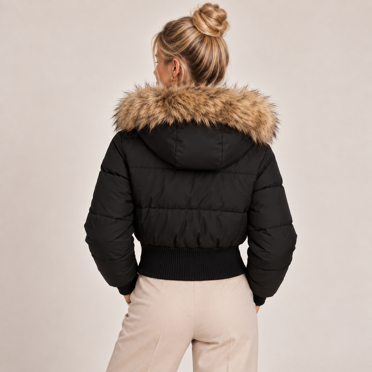 Black cropped puffer jacket back view with faux fur hood trim and ribbed hem
