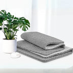Gray textured shower mat with non-slip backing, folded and stacked for bathroom use