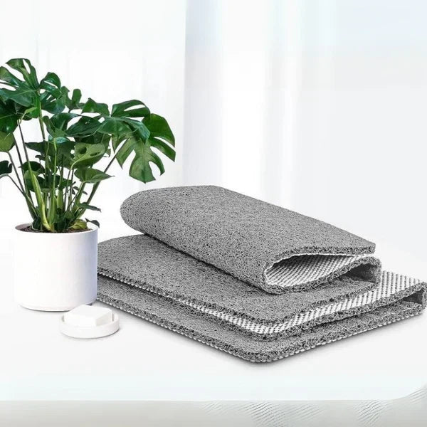 Gray textured shower mat with non-slip backing, folded and stacked for bathroom use