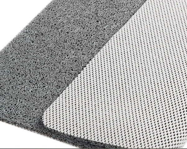 Textured gray shower mat edge detail with lighter backing mesh underside