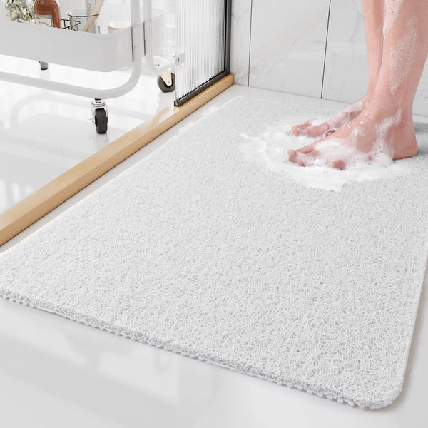 Gray textured bathtub shower mat with smooth beveled edge, person foot resting on top