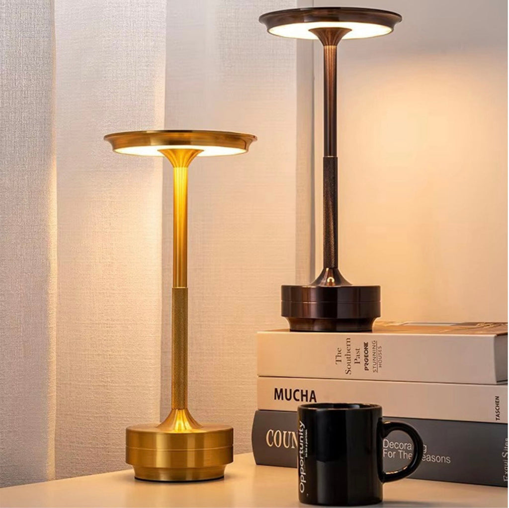 Two cordless LED table lamps with bronze stems and warm glowing round top shades