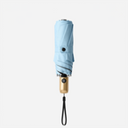 Light blue mini travel umbrella, folded compact design with wrist strap