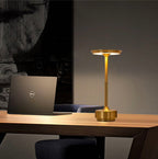 Cordless LED table lamp with brushed bronze stem, round base, and warm lit top