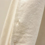 Cream textured knit vest with ribbed turtleneck sleeves, close-up view