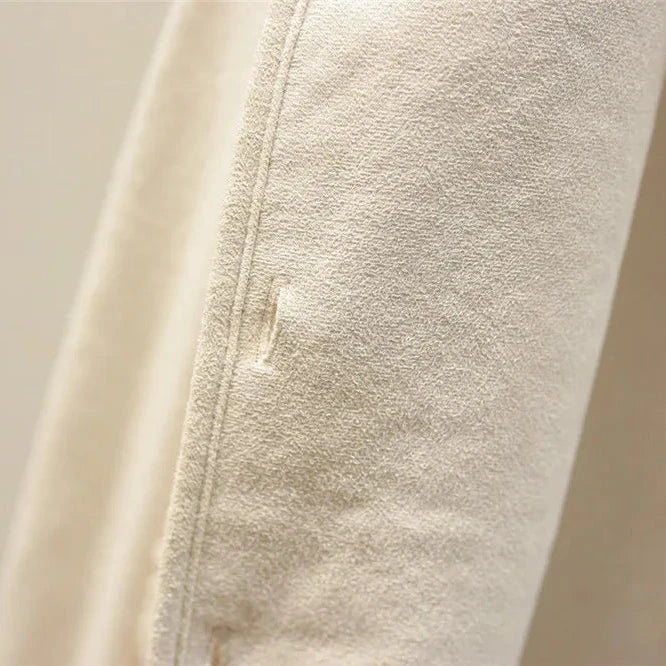 Cream textured knit vest with ribbed turtleneck sleeves, close-up view