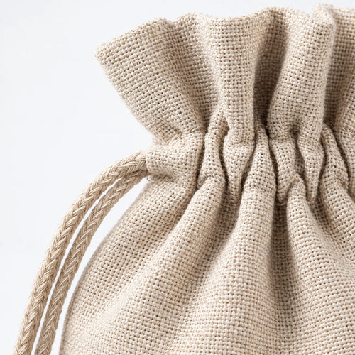 Natural fabric drawstring bag with gathered top and braided string handle