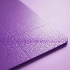 Purple non-slip yoga mat corner close-up, textured surface and folded seam