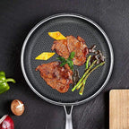 Non-stick stainless skillet with honeycomb interior holding seared meat and herbs