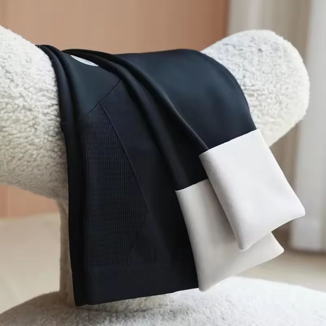 Black maternity leggings with ribbed front panel and smooth waistband, folded