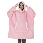 Blush pink oversized wearable blanket hoodie with hood and front kangaroo pocket.