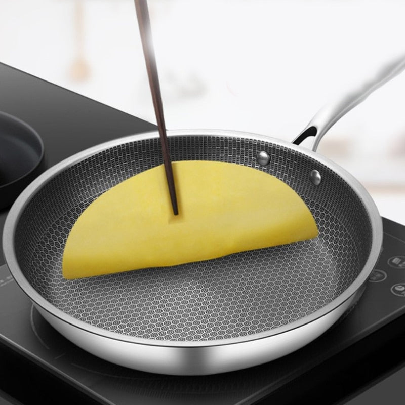 Non-stick frying pan with dark honeycomb coating, pouring liquid into pan surface