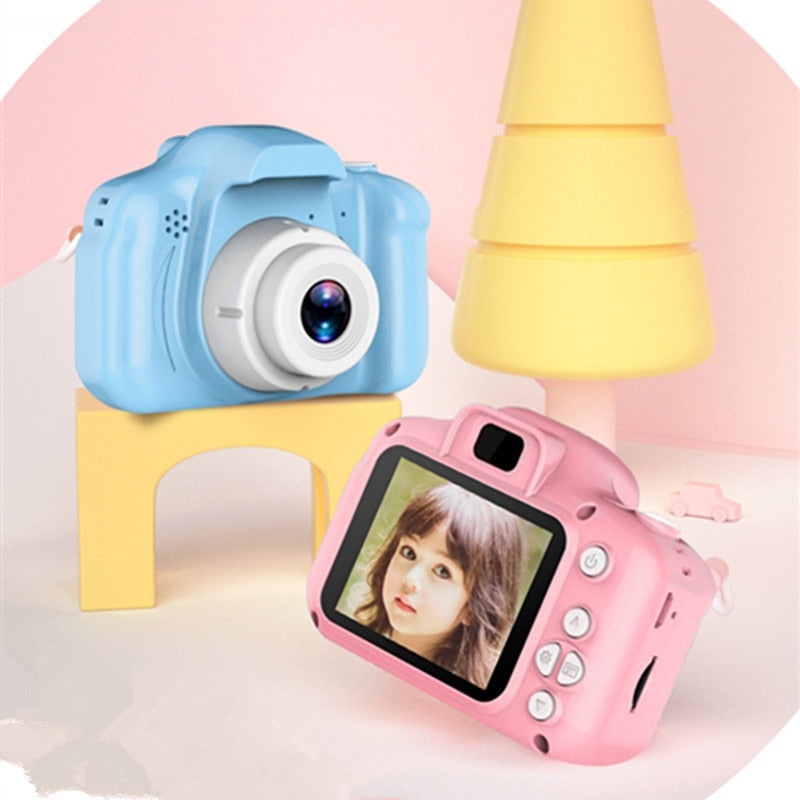 Kids digital camera in blue and pink shockproof cases, showing lens and rear screen