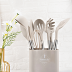 White silicone cooking utensil set in a white holder, stainless steel utensil handles