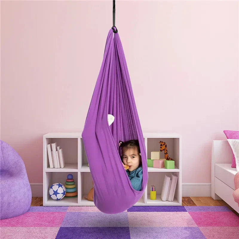 Purple kids' cotton hammock swing cocoon hanging, child peeking from the opening.