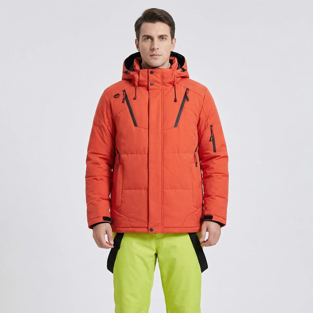 Padded ski jacket and snow pants set with orange hooded jacket and neon green pants.