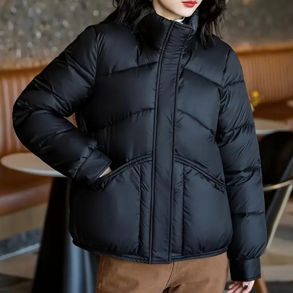 Women’s black puffer jacket with front zipper and angled quilted panel design