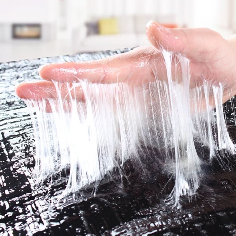 Hand applying clear adhesive strings to a black sticky glue trap surface