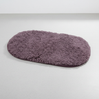 Purple oval microfiber non-slip bath mat with soft shaggy textured surface