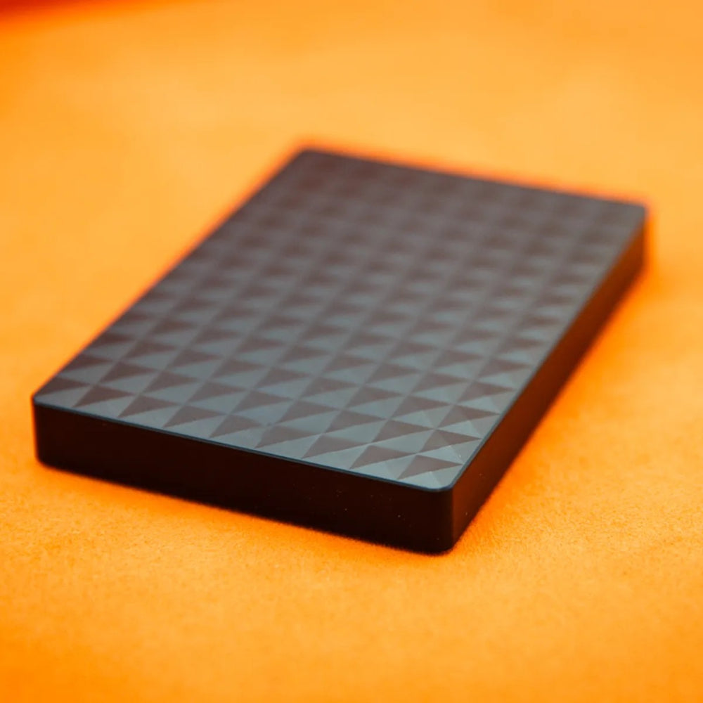 Black external hard drive with geometric textured top, compact rectangular design