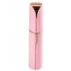 Pink facial hair remover with gold-tone top and central grooming trigger