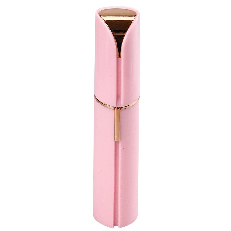 Pink facial hair remover with gold-tone top and central grooming trigger