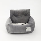 Gray soft-lined dog booster bed with raised bolster and black safety strap