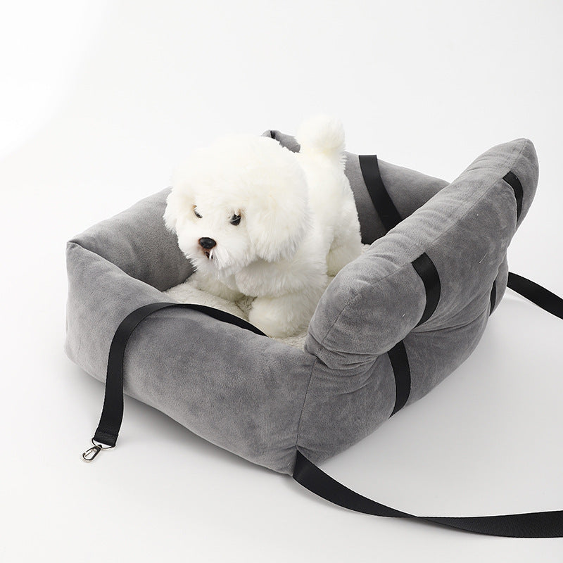 Gray dog booster bed with black straps, plush interior, and small white dog
