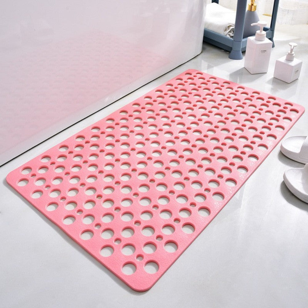 Pink non-slip shower mat with circular drainage holes and grippy textured surface.