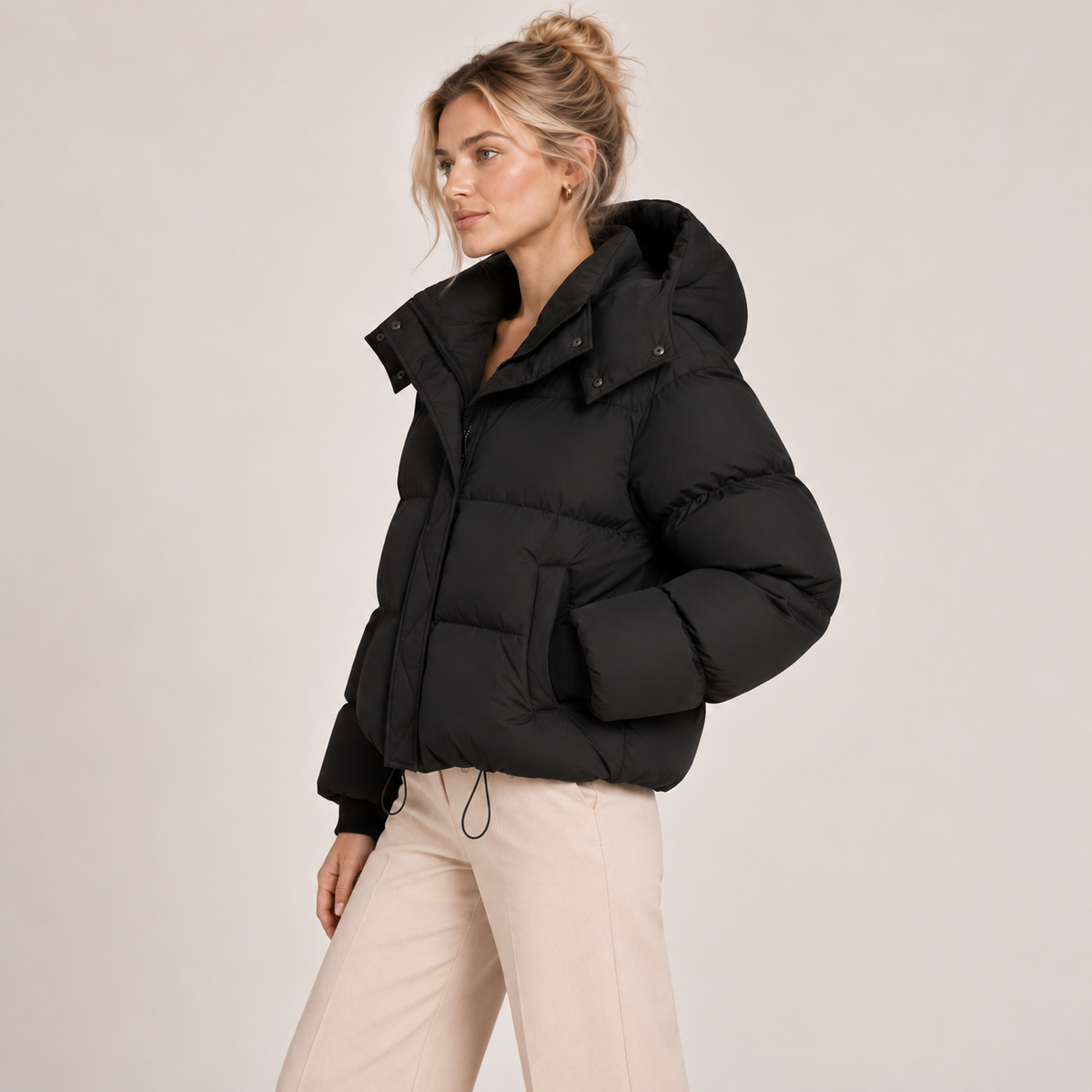 Women's black quilted puffer jacket with oversized hood, button placket and long sleeves