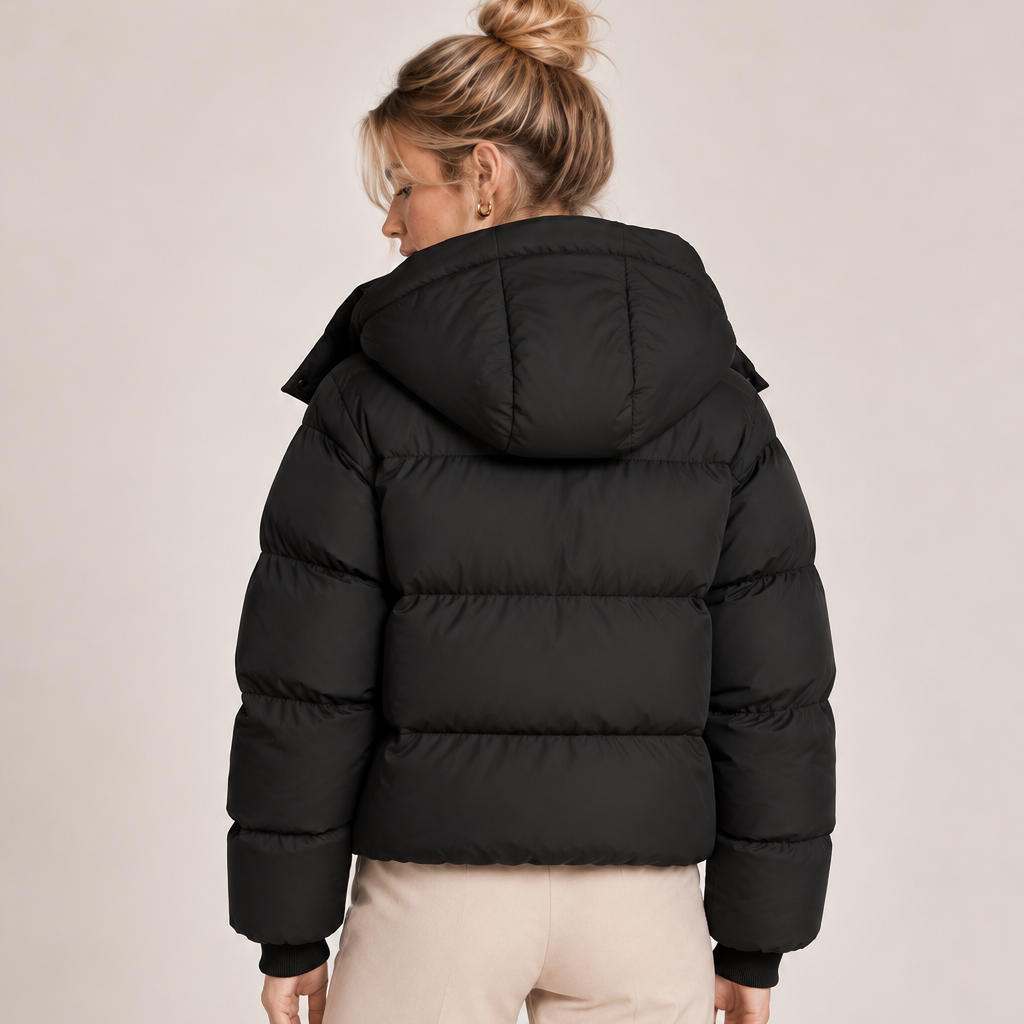 Women's black quilted puffer jacket back view with oversized hood and ribbed cuffs