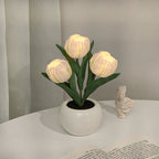 White tulip night light blooms in a white ceramic pot with warm LED glow
