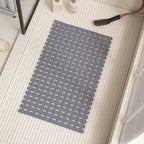Dark gray non-slip bath mat with ridged drainage holes and suction cups, rectangular