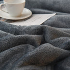 Double-sided flannel and fleece throw blanket, dark gray textured fleece close-up