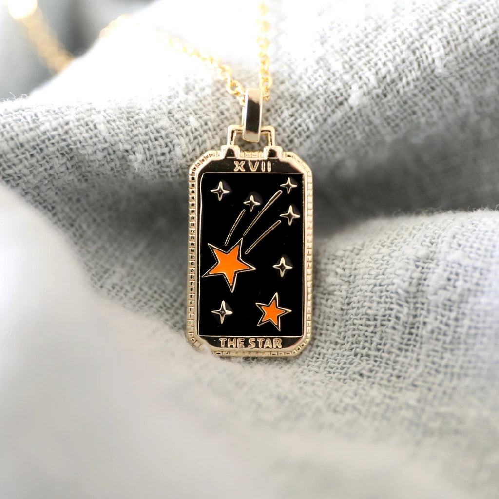 Tarot card pendant necklace with black star card and orange star design on gold chain