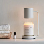 White electric candle warmer lamp with open-top shade over glass jar candle