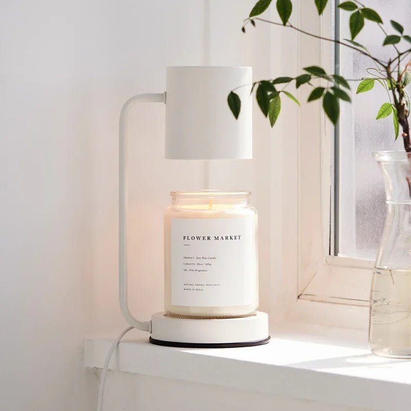 White electric candle warmer lamp with glass jar candle on round base, open-top shade