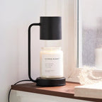 Black electric candle warmer lamp with matte shade and glass jar candle on base