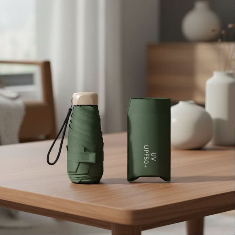 Compact travel umbrella, folded dark green with carry strap and protective cover