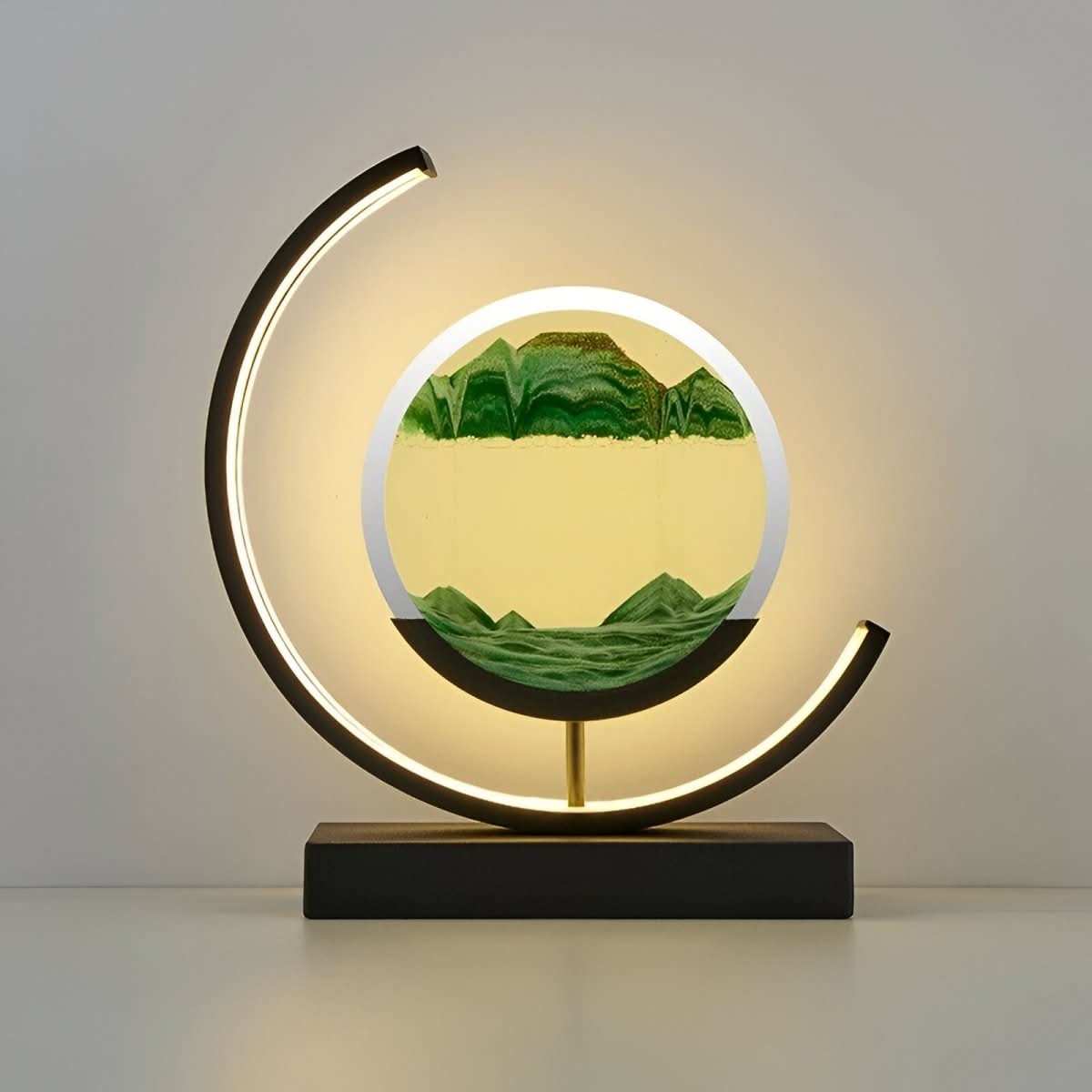 Moving sand LED lamp with circular green sand art and warm glowing crescent ring base