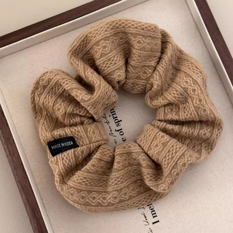 Beige knit oversized hair scrunchie with textured vintage pattern and fabric-covered elastic.